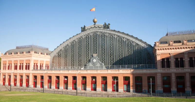 Estação ferroviária de Madrid, com construções em tons laranja e vermelho.